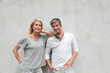 Modern couple standing on concrete wall