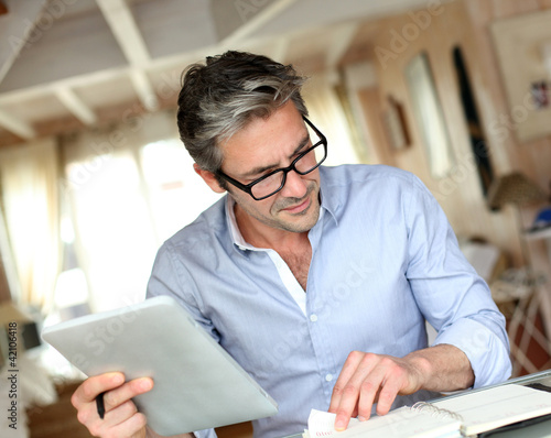 Photo: Handsome businessman with eyeglasses working from home Handsome businessman with eyeglasses working from home
