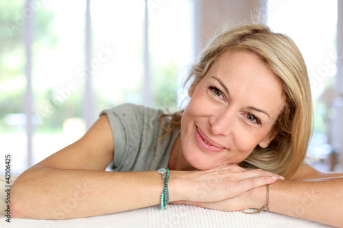 Photo: Beautiful blond mature woman relaxing in sofa Beautiful blond mature woman relaxing in sofa