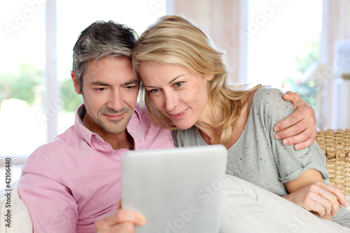 Foto: Couple at home using electronic tablet Couple at home using electronic tablet