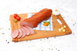 wooden chopping board with sliced ham and spices