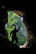 Foto: Man standing in front of a cave entrance Man standing in front of a cave entrance