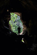 Foto: Man standing in front of a cave entrance Man standing in front of a cave entrance