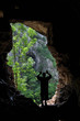 Foto: Man standing in front of a cave entrance Man standing in front of a cave entrance