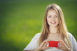 Young beautiful girl holding a blank credit card outdoors