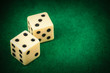 Two dice on a green gaming table with space for text