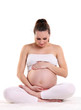 Photo: Young pregnant woman sitting in a lotus position Young pregnant woman sitting in a lotus position