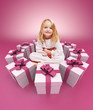 Foto: Happy little girl surrounded by gifts pink Happy little girl surrounded by gifts pink