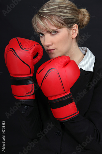 Photo: Female office worker wearing boxing gloves Female office worker wearing boxing gloves
