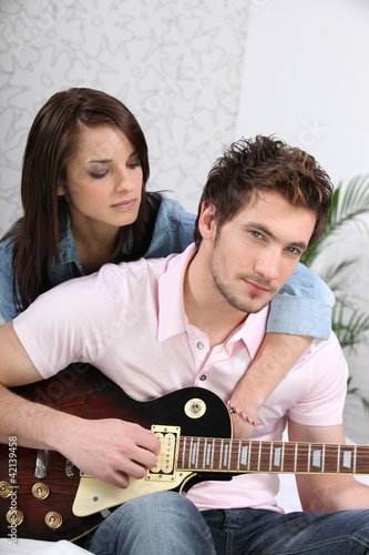 Foto: Young woman and young man with guitar Young woman and young man with guitar