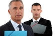 businessman with his assistant trailing behind him
