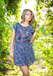 Young attractive girl with blue dress outdoor on the field