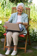 Uroma mit Laptop im Garten