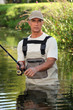 Fisherman wading in river