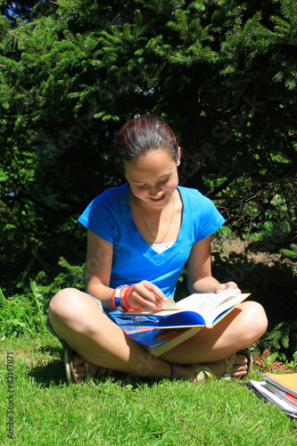 Photo: Young girl doing homework outdoors Young girl doing homework outdoors