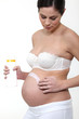 Pregnant woman applying cream to belly