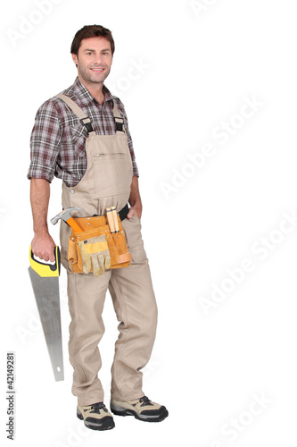 Foto: Builder with hand saw. Builder with hand saw.