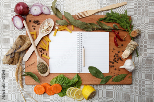 Photo: notebook for recipes and spices on wooden table notebook for recipes and spices on wooden table