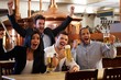 Happy fans watching TV in pub cheering