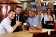 Happy fans watching TV in pub cheering