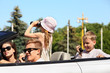 Young father, mother and two children ride in convertible car