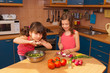 Happy smiling kids cooking salad at kitchen