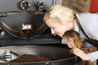 frau schaut auf geröstete kaffeebohnen