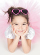Beautiful little girl in a pink dress with glasses over white