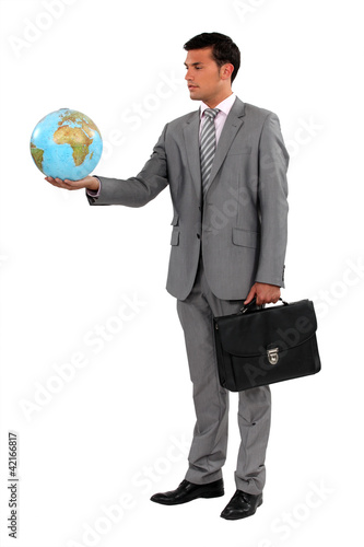 Foto: Businessman with briefcase holding globe Businessman with briefcase holding globe