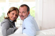 Portrait of happy senior couple sitting in sofa