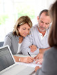 Senior couple signing financial contract