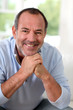 Portrait of senior man sitting in sofa at home