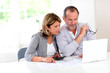 Photo: Couple reading construction plan at home with use of laptop Couple reading construction plan at home with use of laptop