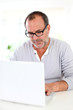 Senior businessman working on laptop from home