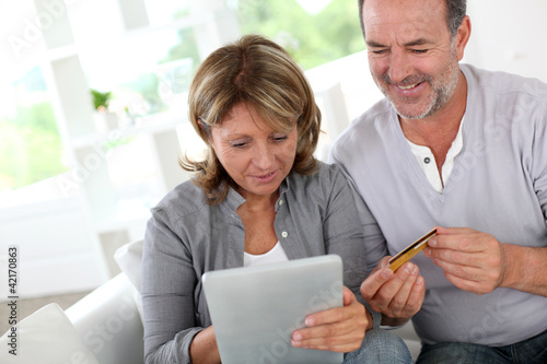 Foto: Senior couple using credit card to shop online Senior couple using credit card to shop online