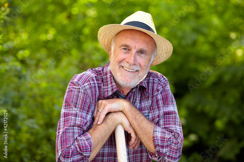 Foto: Portrait of senior gardener with straw hat Portrait of senior gardener with straw hat