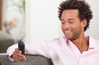 Photo: Man sat on sofa sending text message Man sat on sofa sending text message