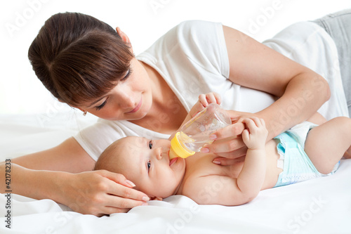 Foto: young mother feeding her adorable baby young mother feeding her adorable baby
