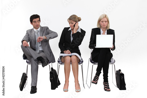 Photo: Business people sitting in a row Business people sitting in a row