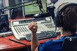 Photo: Dj working in front of a microphone on the radio, from the back Dj working in front of a microphone on the radio, from the back