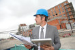 Architect checking plan of construction with tablet