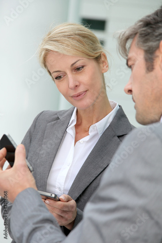 Foto: Business people exchanging phone numbers Business people exchanging phone numbers