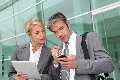 Foto: Business team meeting outside with tablet Business team meeting outside with tablet