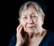 Sad old senior woman looking down and crying