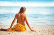 beautiful woman sitting from the back on beach, bali