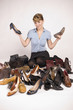 Eine Frau ist umgeben von Schuhen