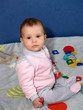 Младенец держит в руках игрушки