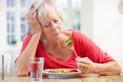Photo: Sick older woman trying to eat Sick older woman trying to eat