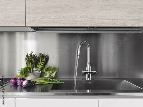 Foto: verdure fresche sul piano di acciaio di una cucina moderna verdure fresche sul piano di acciaio di una cucina moderna