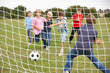 Boys playing soccer in park